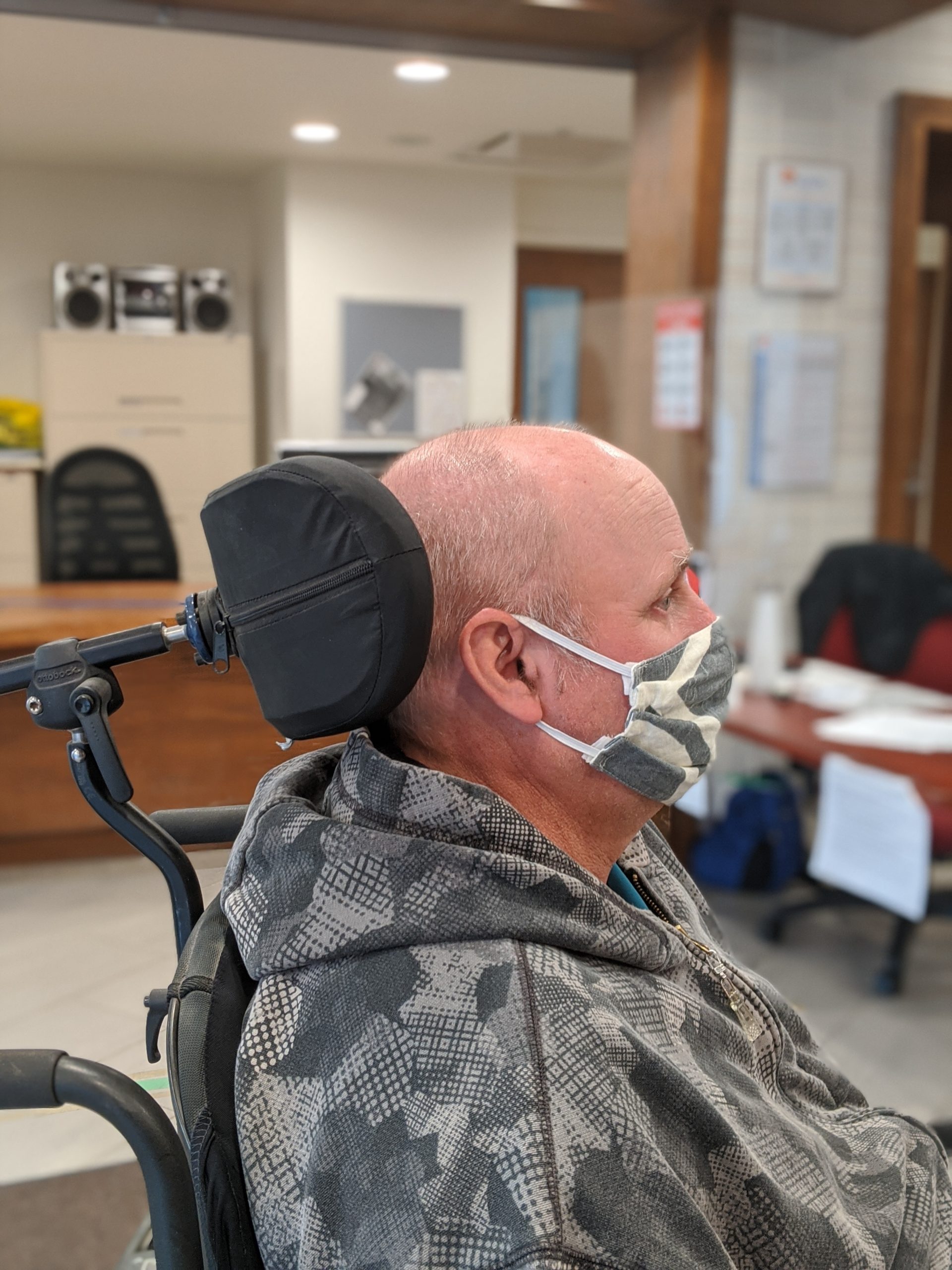 A man in a wheelchair with a mask on